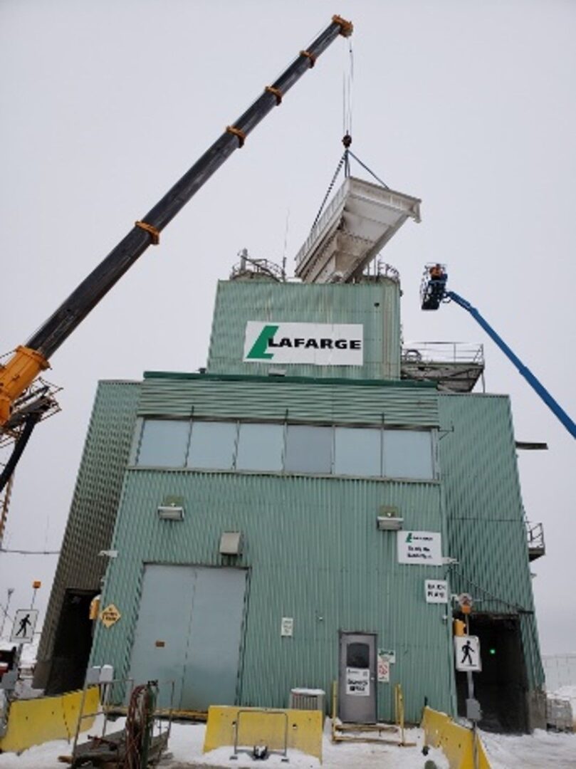 A crane is lifting the roof of a building.