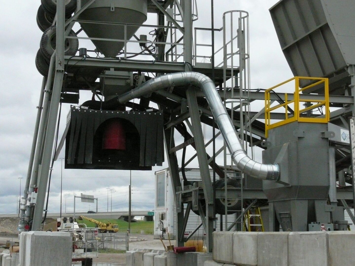 A cement plant with pipes and a large bag of cement.