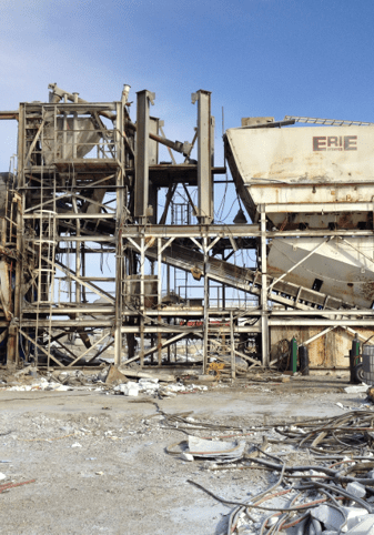 A large industrial building with rubble and debris around it.