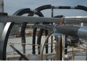 A close up of pipes on top of an industrial building.