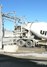 A cement truck parked in front of power lines.